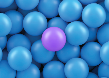 uma bola roxa no meio de várias bolas azuis