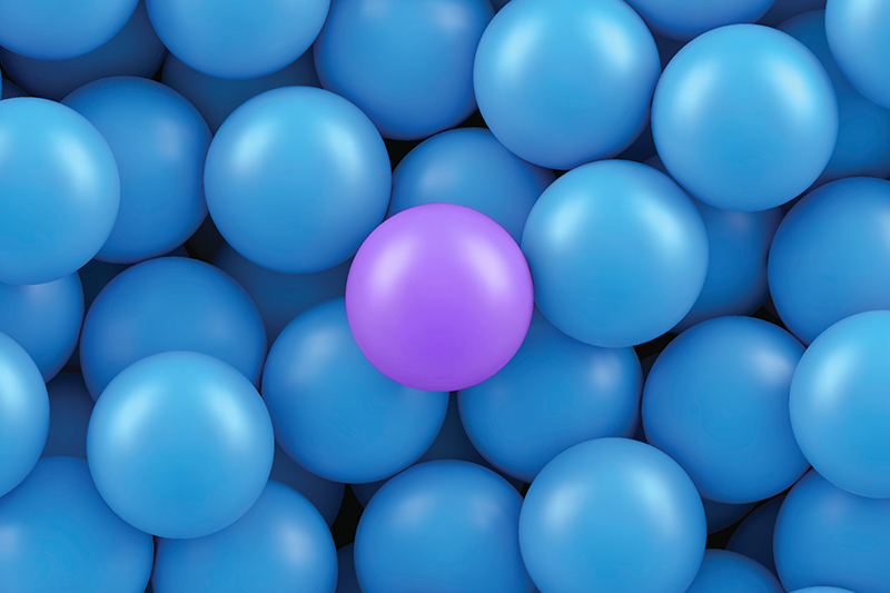 uma bola roxa no meio de várias bolas azuis